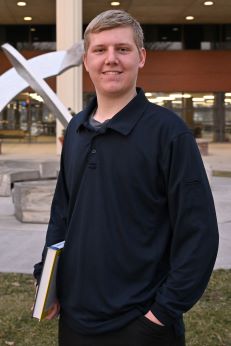 Student holding a textbook in front area