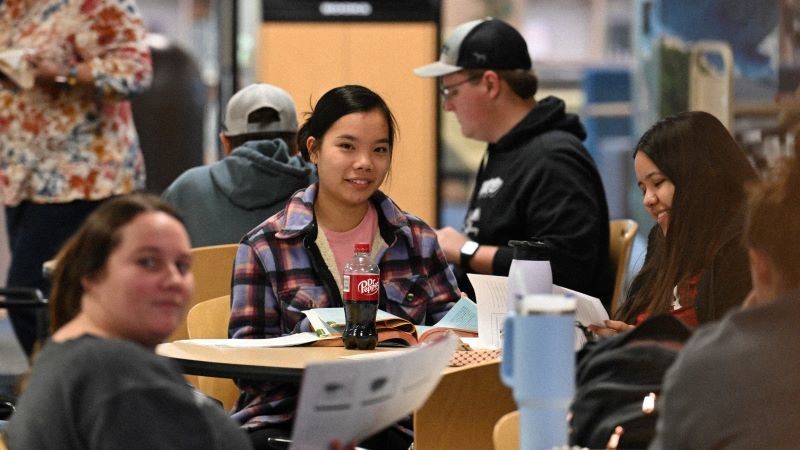 Group of students sitting at tables near Hammes Cafe